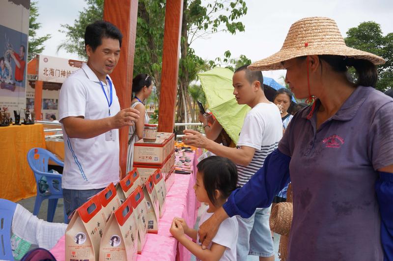 图为游园的客人正在询问沙蟹汁。苏远志拍摄