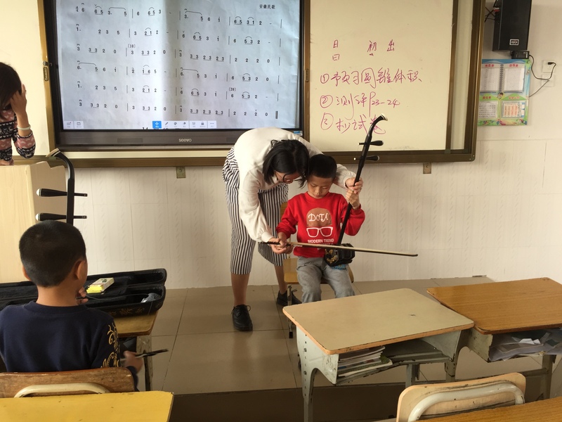 图为非遗中心老师在教授学生学习传统乐器.jpg